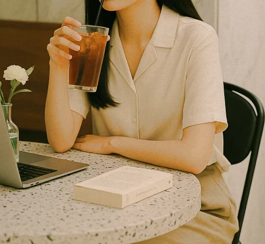 인견 셔츠를 입은 여성이 카페 테이블에서 여유를 즐기는 장면