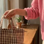 거실 장식장에서 체크 피크닉 가방을 챙겨 나서는 핑크 가디건 벚꽃룩 코디