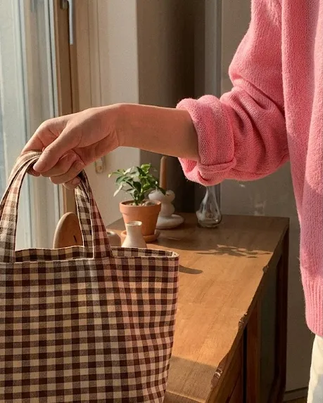 거실 장식장에서 체크 피크닉 가방을 챙겨 나서는 핑크 가디건 벚꽃룩 코디