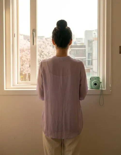 봄 햇살 아래 파스텔 블라우스를 입은 여성의 뒷모습