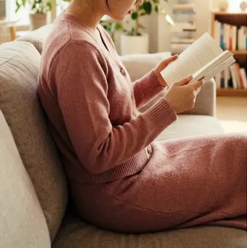 파스텔 컬러의 니트 가디건과 니트 스커트/팬츠 셋업을 입은 여성