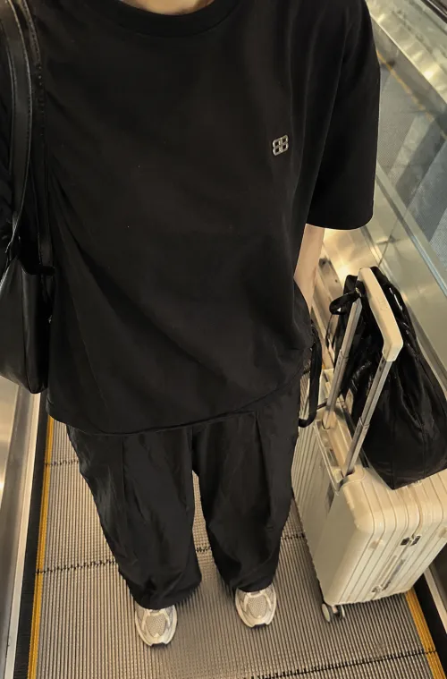 공항 무빙워크에서 찍은 무채색 오버핏 코디 목 아래 착샷