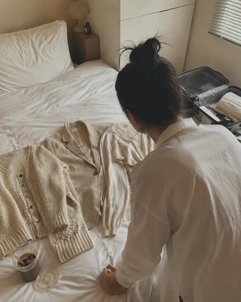 여름가디건 - 좁은 원룸 침대 위에 니트가디건 린넨자켓 볼레로가디건 세 벌이 펼쳐진 모습
